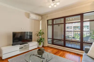 a living room with a tv and a large window at Stay In Avenue Arriaga 10, by Pausa H. Rentals in Funchal
