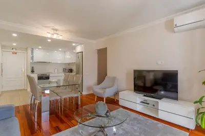 a living room with a television and a table and chairs at Stay In Avenue Arriaga 10, by Pausa H. Rentals in Funchal
