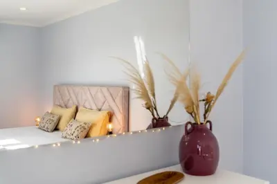 a mirror on a shelf with pillows and a vase at Stay In St. Catarina Park, by PAUSA H. Rentals in Funchal