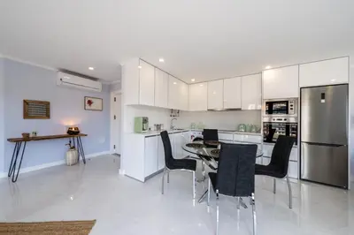 a kitchen with a table and chairs and a refrigerator at Stay In St. Catarina Park, by PAUSA H. Rentals in Funchal
