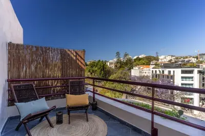 a balcony with two chairs and a view of a city at Stay In St. Catarina Park, by PAUSA H. Rentals in Funchal