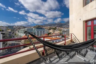 a hammock on a balcony overlooking a city at Stay In St. Catarina Park, by PAUSA H. Rentals in Funchal