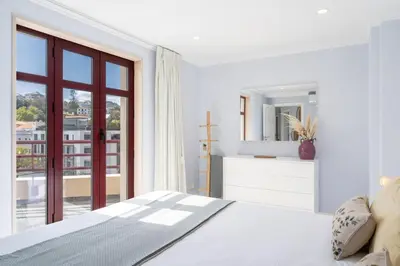 a white bedroom with a bed and a large window at Stay In St. Catarina Park, by PAUSA H. Rentals in Funchal