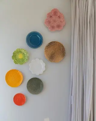 a group of different colored plates on a wall at Q.Vitória PentHouse, by Pausa Holiday Rentals in Funchal