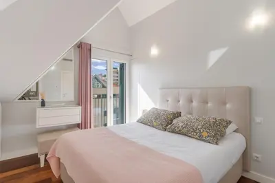 a white bedroom with a large bed with a window at Q.Vitória PentHouse, by Pausa Holiday Rentals in Funchal