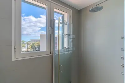 a bathroom with a shower and a window at Q.Vitória PentHouse, by Pausa Holiday Rentals in Funchal
