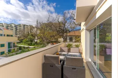 a balcony with a table and chairs and a view at Q.Vitória PentHouse, by Pausa Holiday Rentals in Funchal