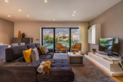 a living room with a large couch and a flat screen tv at Renala II - Apart, With Pool, by Pausa H. Rentals in Funchal