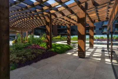 a wooden pergola in front of a building at Renala II - Apart, With Pool, by Pausa H. Rentals in Funchal