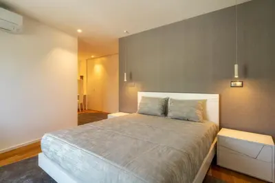 a bedroom with a large bed with a gray wall at Renala II - Apart, With Pool, by Pausa H. Rentals in Funchal
