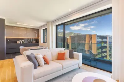 a living room with a white couch and a large window at Renala III, by Pausa Holiday Rentals in Funchal