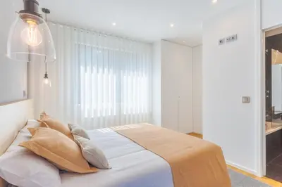a bedroom with a bed with white sheets and a window at Renala III, by Pausa Holiday Rentals in Funchal