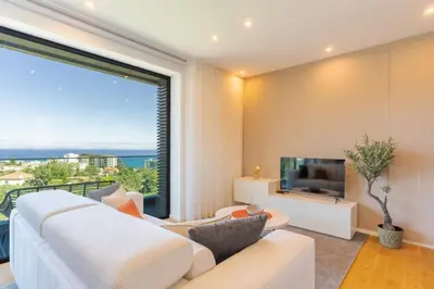 a living room with a white couch and a large window at Renala III, by Pausa Holiday Rentals in Funchal