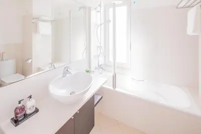 a white bathroom with a sink and a bath tub at Rodamar Penthouse in Funchal