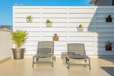 two chairs sitting in front of a wall with potted plants at Rodamar Penthouse in Funchal
