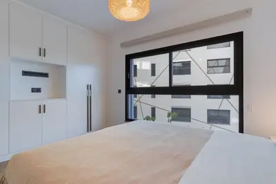 a bedroom with a large window and a bed at Stay In S.Lucas Residence, by Pausa H. Rentals in Funchal
