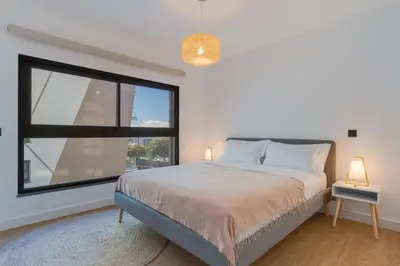 a bedroom with a bed and a large window at Stay In S.Lucas Residence, by Pausa H. Rentals in Funchal
