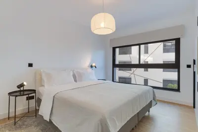 a white bedroom with a large bed and a window at Stay In S.Lucas Residence, by Pausa H. Rentals in Funchal