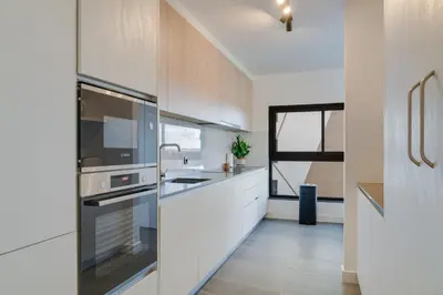a kitchen with white cabinets and a sink at Stay In S.Lucas Residence, by Pausa H. Rentals in Funchal