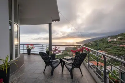 a balcony with two chairs and a table with a view at Casa Almada in Ribeira Brava