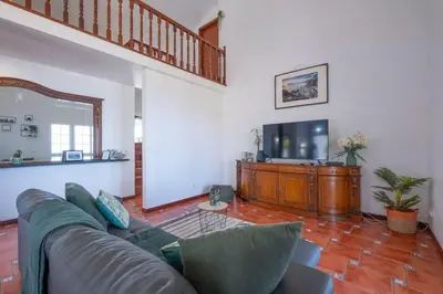 a living room with a couch and a flat screen tv at Casa Almada in Ribeira Brava