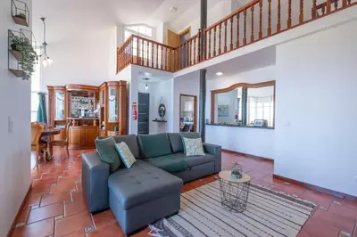 a living room with a blue couch and a staircase at Casa Almada in Ribeira Brava