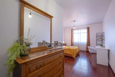 a bathroom with a dresser with a mirror and a bed at Casa Almada in Ribeira Brava