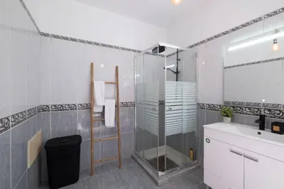 a bathroom with a glass shower and a sink at Casa Almada in Ribeira Brava