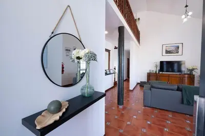 a living room with a mirror and a couch at Casa Almada in Ribeira Brava
