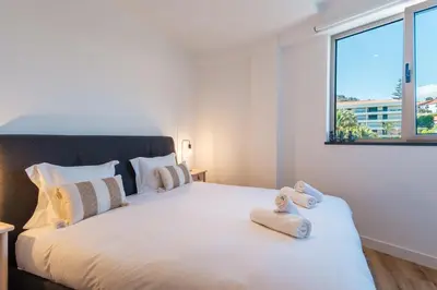 a bedroom with a large white bed with towels on it at GuestReady - Elegant Madeira Retreat in Funchal