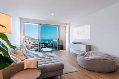 a living room with a couch and a large window at GuestReady - Elegant Madeira Retreat in Funchal
