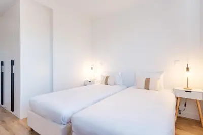 two beds in a room with white walls at GuestReady - Elegant Madeira Retreat in Funchal