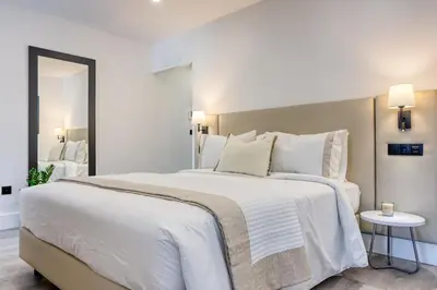 a bedroom with a large white bed and a mirror at BSE15 Apartments 3G, a Home in Madeira in Funchal