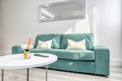 a living room with a green couch and a white table at BSE15 Apartments 3G, a Home in Madeira in Funchal