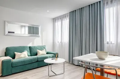 a living room with a green couch and a table at BSE15 Apartments 3G, a Home in Madeira in Funchal