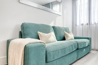 a green couch with pillows on it in a room at BSE15 Apartments 3G, a Home in Madeira in Funchal