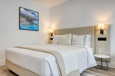 a bedroom with a large white bed with a picture on the wall at BSE15 Apartments 3H, a Home in Madeira in Funchal
