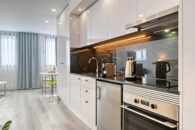 a kitchen with white cabinets and black counter tops at BSE15 Apartments 4K, a Home in Madeira in Funchal