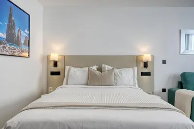 a bedroom with a large bed and a blue chair at BSE15 Apartments 4K, a Home in Madeira in Funchal