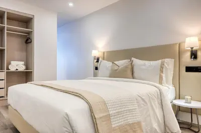 a bedroom with a large white bed and a table at BSE15 Apartments 2F, a Home in Madeira in Funchal