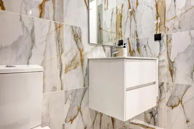 a white bathroom with a sink and a mirror at BSE15 Apartments 2F, a Home in Madeira in Funchal