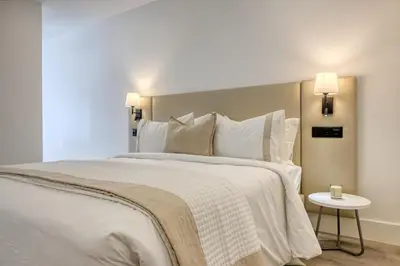 a bedroom with a large bed with white sheets and pillows at BSE15 Apartments 4L, a Home in Madeira in Funchal