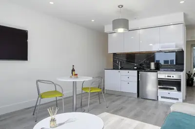 a kitchen with white cabinets and a table and chairs at BSE15 Apartments 4L, a Home in Madeira in Funchal