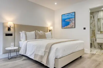 a white bedroom with a large white bed and a window at BSE15 Apartments 4L, a Home in Madeira in Funchal