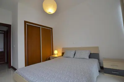 a bedroom with a bed with a blue bedspread at Vilas Espírito Santo in Porto Santo