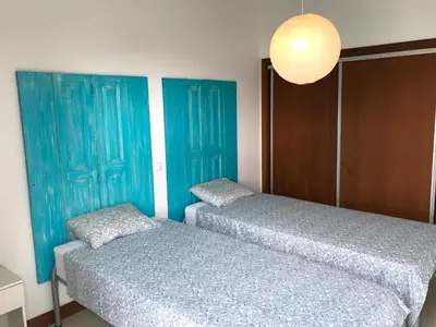 two beds in a room with blue doors at Vilas Espírito Santo in Porto Santo