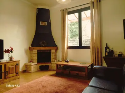 a living room with a fireplace and a couch at Quartos em Vila Paradise Porto da Cruz in Porto da Cruz