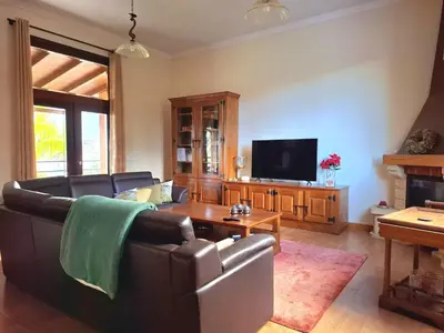 a living room with a couch and a tv at Quartos em Vila Paradise Porto da Cruz in Porto da Cruz