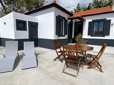 a wooden table and chairs in front of a house at Casa Isa - Funchal in Funchal