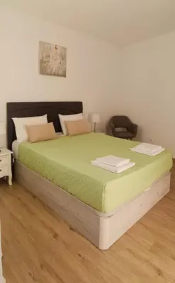 a bedroom with a large bed with green sheets at Casa Isa - Funchal in Funchal